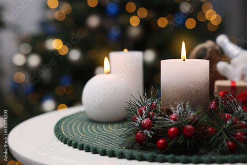 Beautiful burning candles and Christmas decor on white table indoors, space for text