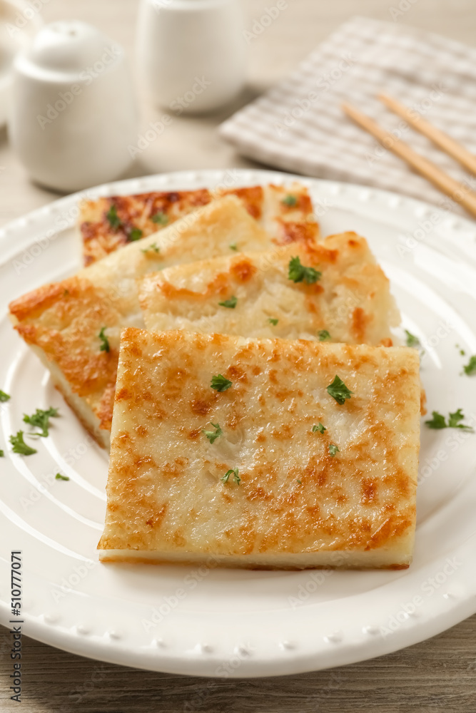Delicious turnip cake with parsley served on wooden table, closeup