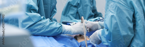 Foto Professional doctors performing frontal sinus trephination in surgery room, closeup