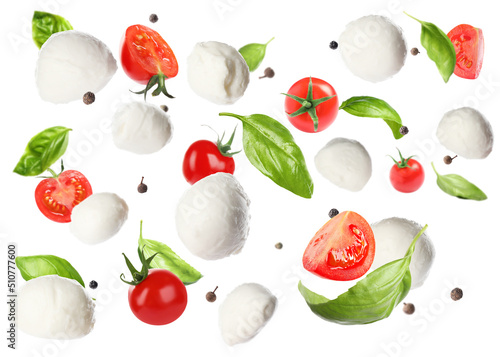 Mozzarella cheese balls, tomatoes, basil leaves and peppercorns for caprese salad flying on white background