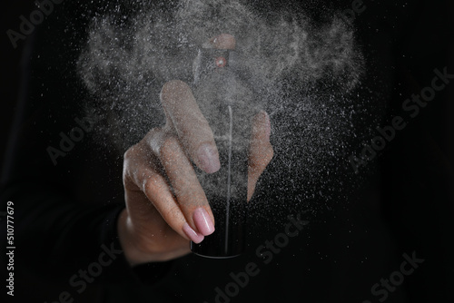 Wallpaper Mural Young woman using pepper spray on black background, closeup