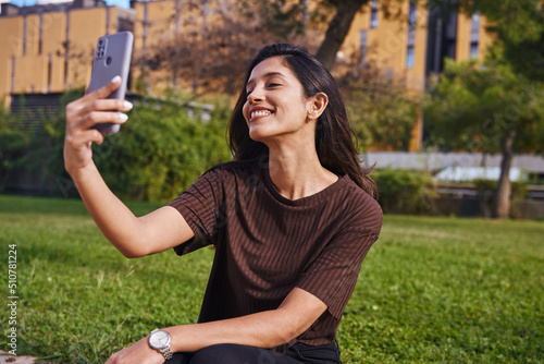 Beautiful smiling businesswoman sitting in park