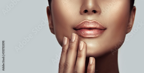 Beautiful young woman's lips closeup. Plastic surgery, fillers, injection. Model girl's face, healthy nails, and perfect skin, youth concept. Natural make-up. Youth and beauty. Health care concept. photo