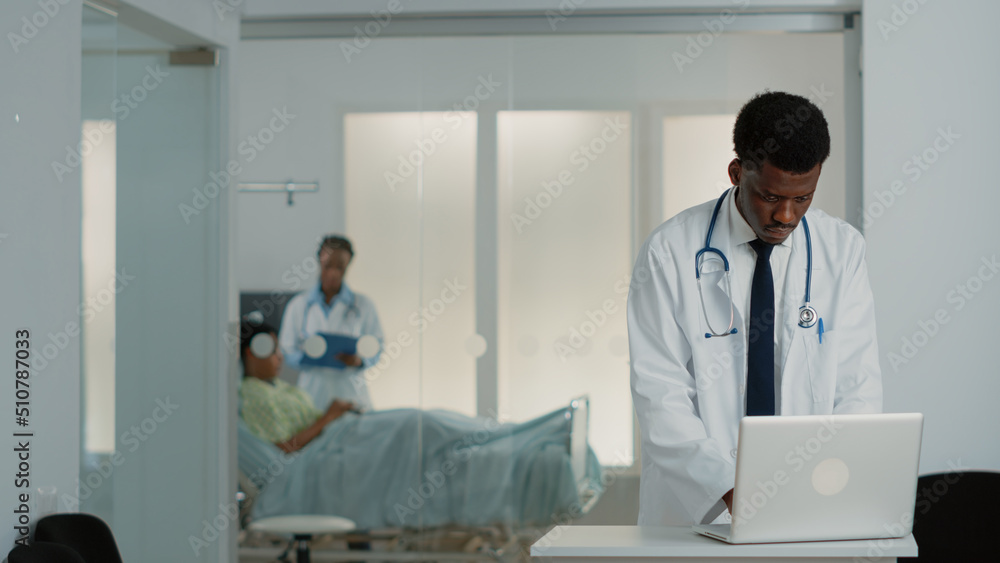 Obraz premium General practitioner looking at modern laptop to work on medical treatment and healthcare system. Physician using device to find checkup information to cure patient with disease.