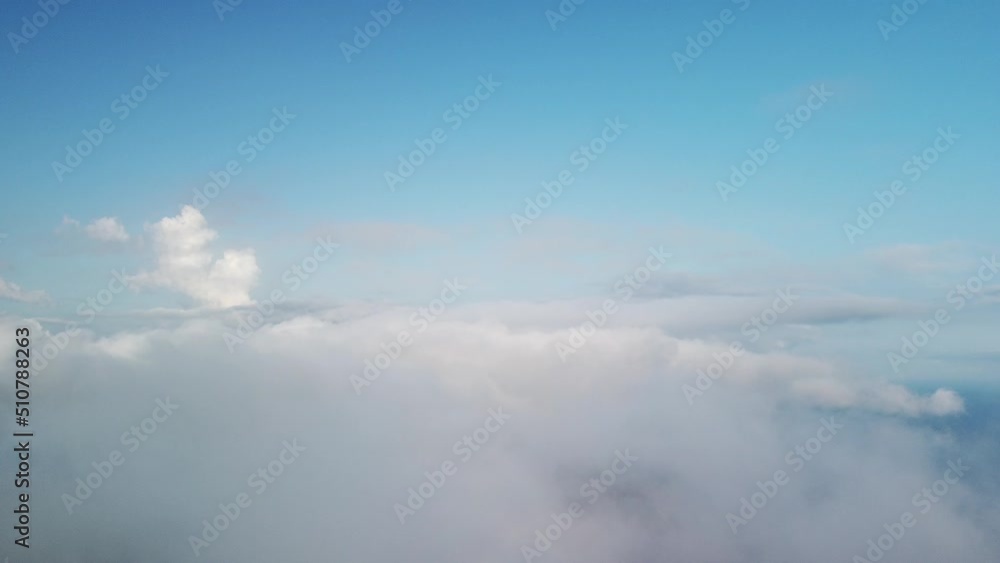 Aerial view. Blue sky sun and fog over calm sea. The drone flies over foggy and fluffy clouds. Abstract aerial nature summer ocean sunset sea and sky background. Vacation, travel and holiday concept. Aerial view. Blue sky sun and fog over calm sea. The drone flies over foggy and fluffy clouds. Abstract aerial nature summer ocean sunset sea and sky background. Vacation, travel and holiday concept.