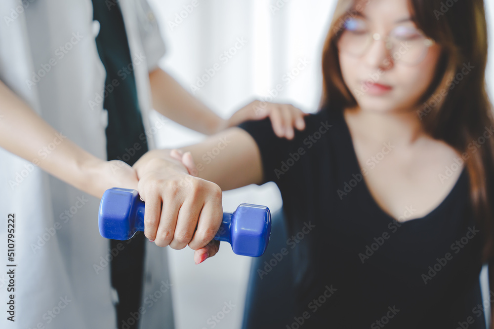 Physical therapist giving dumbbell exercises about the arms and shoulders of female patients physical therapy concept