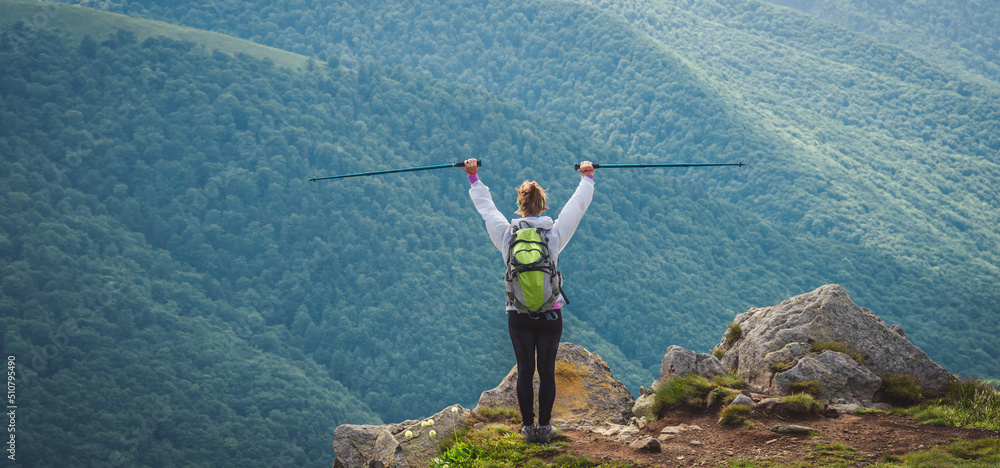 Naklejka premium Young woman n the top of the mountains