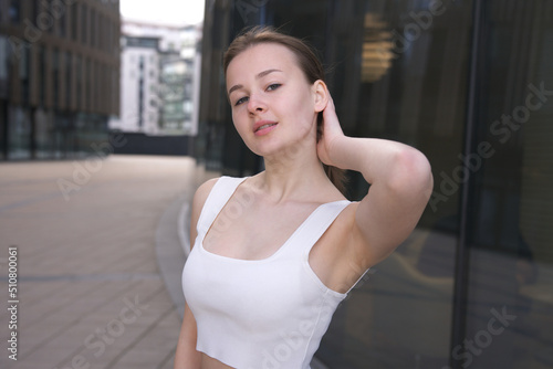 portrait of happy beautiful positive cheerful young woman, pretty teen teenager girl student is smiling standing outdoors with her hand, arm raised up, showing armpit in top T-shirt looking at camera Free Download portrait of happy beautiful positive cheerful young woman, pretty teen teenager girl student is smiling standing outdoors with her hand, arm raised up, showing armpit in top T-shirt looking at camera - GFXLoad