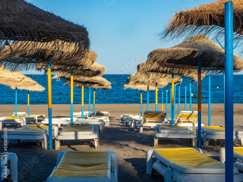 Hamacas y parasoles de playa bajo el sol de Torremolinos photo