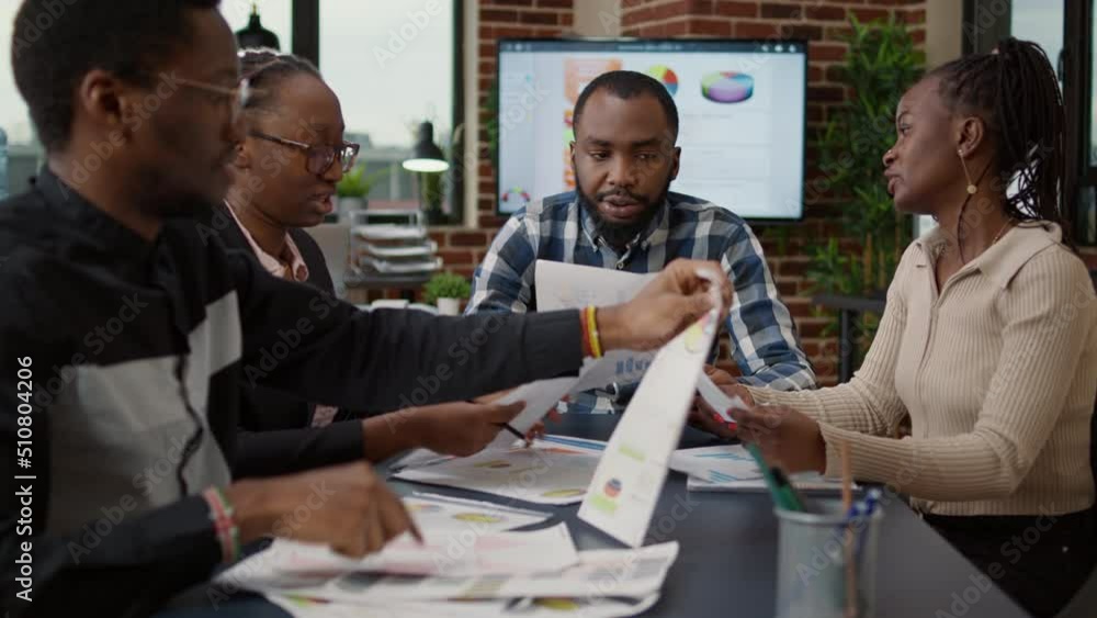 Company employees using business charts on files to plan project and presentation strategy. Group of people looking at documents with research data, marketing statistics and analysis diagram. Company employees using business charts on files to plan project and presentation strategy. Group of people looking at documents with research data, marketing statistics and analysis diagram.