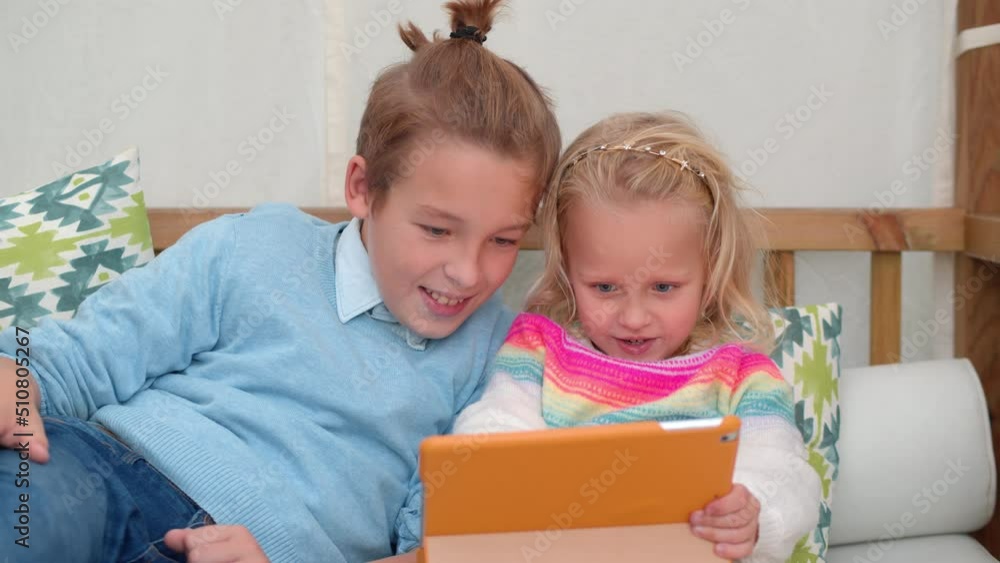Brother and little sister play a computer game