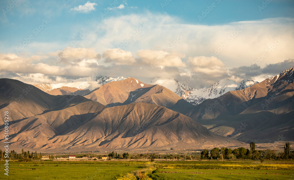 Beautiful scenic shot of fields and the Tian Shan Mountains in Kyrgyzstan.