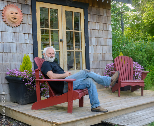 Man taking a break from gardening sitting on a patio in a garden, British Columbia, Canada photo