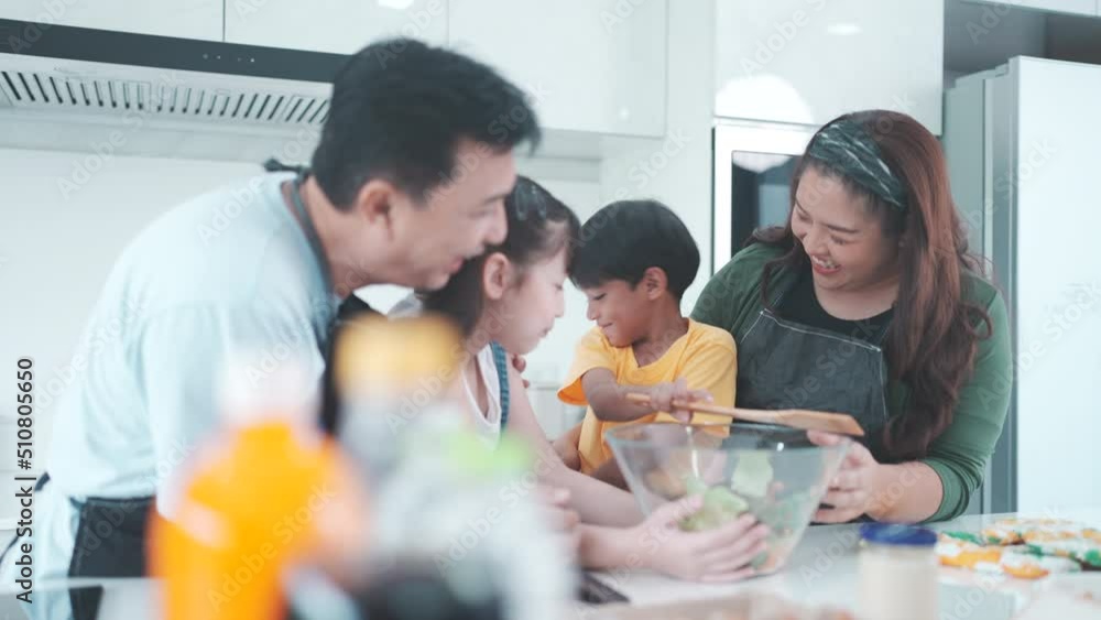 Asian family with children enjoy and happy to cooking in kitchen at home, happiness lifestyle of people who parenting to cook together, smile and joy with eating food at dinner or morning time Asian family with children enjoy and happy to cooking in kitchen at home, happiness lifestyle of people who parenting to cook together, smile and joy with eating food at dinner or morning time