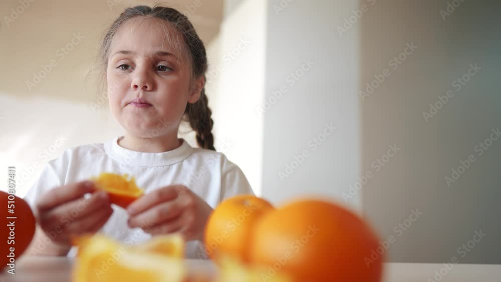 girl child eating oranges. happy family fruit healthy food kid concept dream. little girl daughter eating oranges at the table in the kitchen indoors. juicy fruits oranges are for a healthy diet girl child eating oranges. happy family fruit healthy food kid concept dream. little girl daughter eating oranges at the table in the kitchen indoors. juicy fruits oranges are for a healthy diet