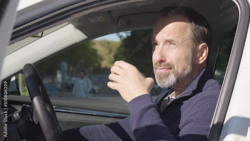 A middle-aged handsome Caucasian man drinks a hot drink and relaxes in a car - closeup A middle-aged handsome Caucasian man drinks a hot drink and relaxes in a car - closeup