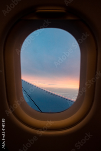 View from an airplane window of a sunrise from the sky