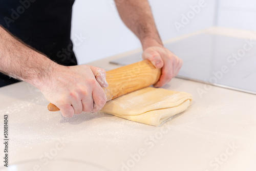 Man cooking homemade croissants, preparing the puff pastry