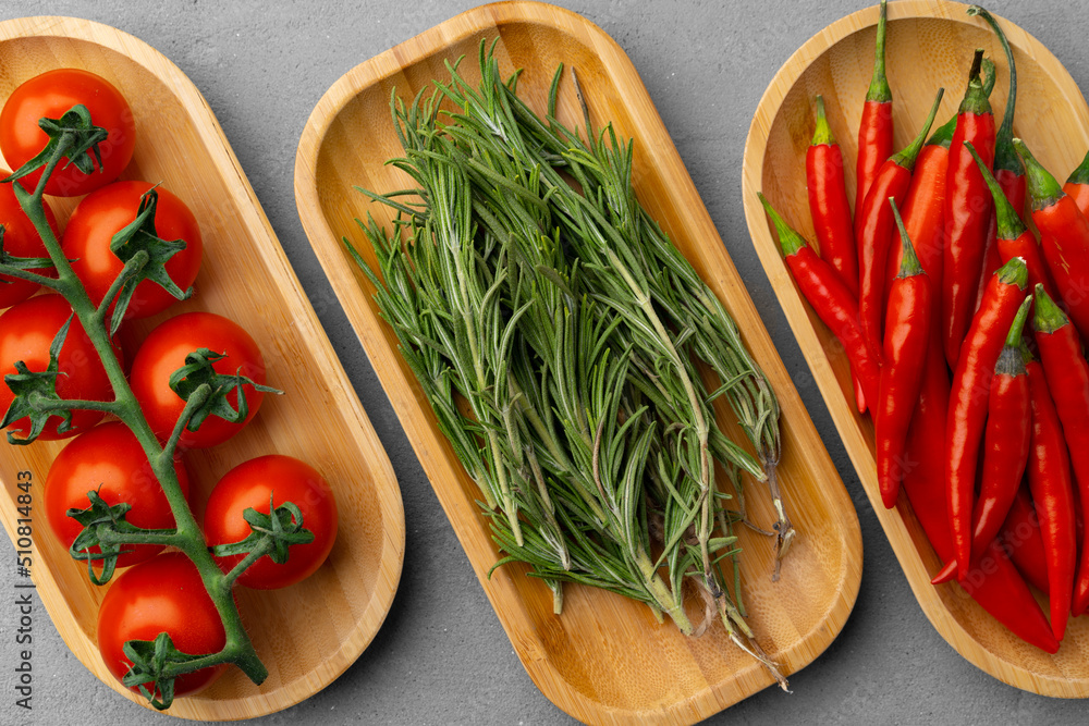 Fresh tomatoes, rosemary and chili peppers on gray background Fresh tomatoes, rosemary and chili peppers on gray background