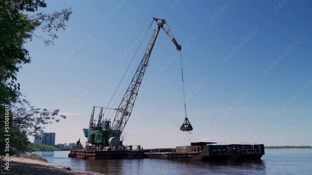 4K view of a floating crane unloading sand from a moored barge onto the beach. Preparing for the summer beach season. 4K view of a floating crane unloading sand from a moored barge onto the beach. Preparing for the summer beach season.
