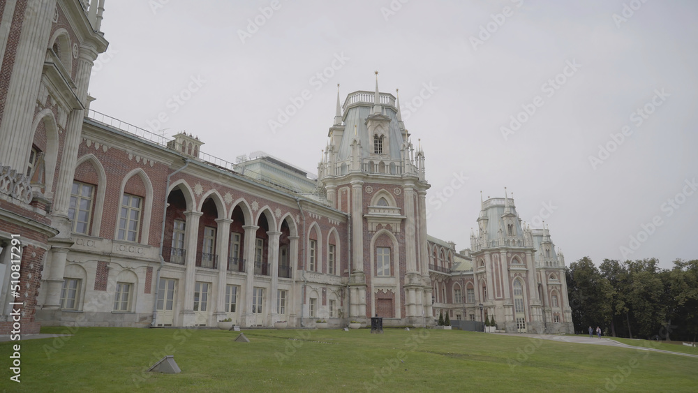 Palace and Park ensemble in Tsaritsyno, Russia. Action. Facade of the Grand Palace, beautiful historic building and green grass on cloudy sky background.