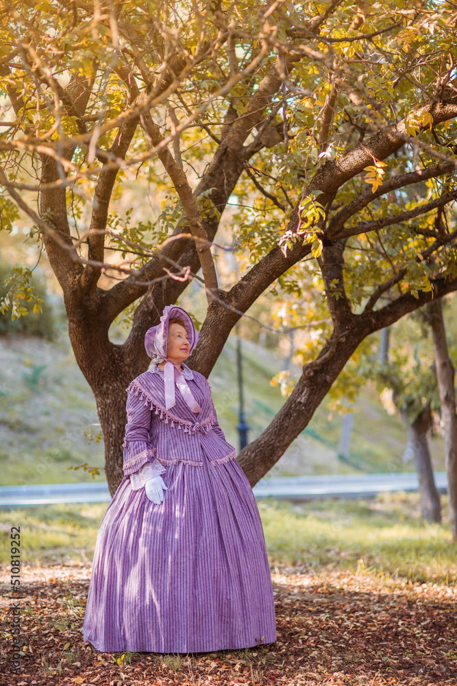 Woman in victorian dress walking in the park. Vintage fashion. Woman in victorian dress walking in the park. Vintage fashion.