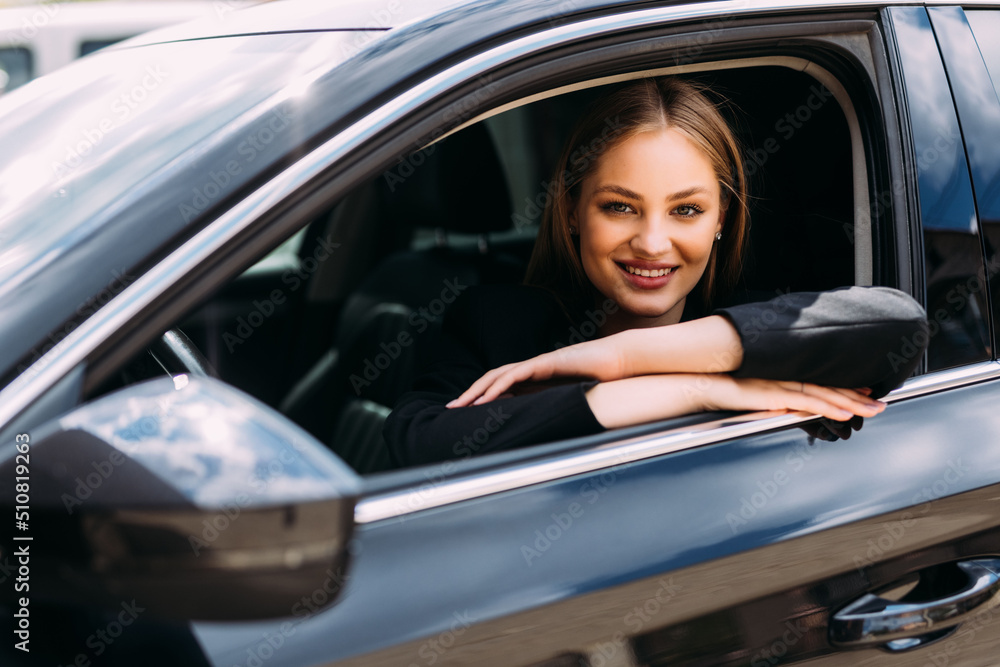 Beautiful young smiling woman driving her car.