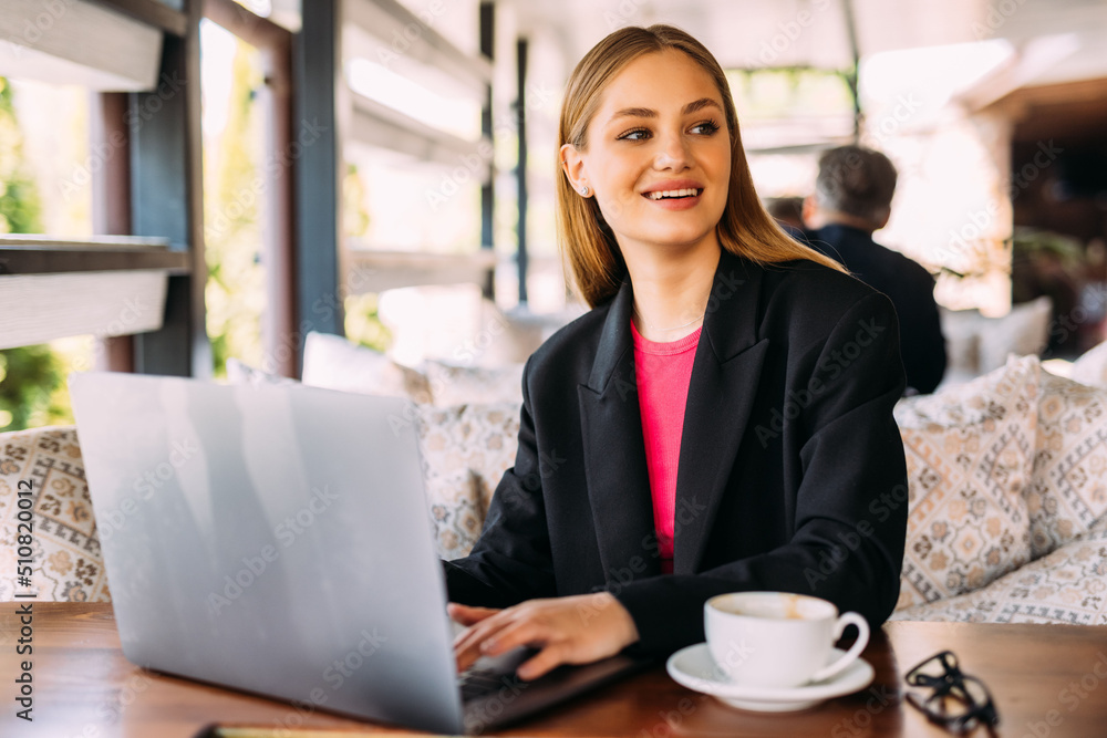 Beautiful business woman dreaming about something while sitting with portable net-book in modern cafe bar Beautiful business woman dreaming about something while sitting with portable net-book in modern cafe bar