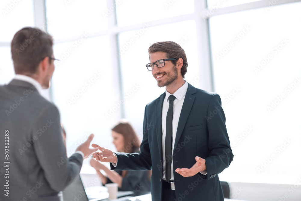 businessman talking with a colleague standing in the office businessman talking with a colleague standing in the office