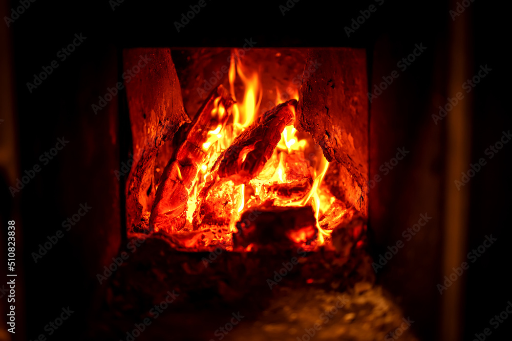 Burning wood in a stove. Firewood, coal and amber ash close-up. Red flames and glowing charcoal. The concept of home and warmth. Close-up of burning wood in the fireplace. Burning wood in a stove. Firewood, coal and amber ash close-up. Red flames and glowing charcoal. The concept of home and warmth. Close-up of burning wood in the fireplace.