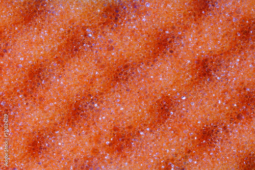 Wavy texture of orange washcloth macro close-up.