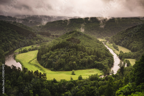 Tombeau du Géant on a rainy summer day in South Belgium, with green pine forest and Semois river on a cloudy sky photo