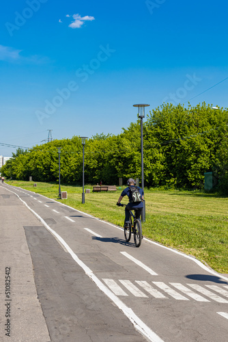  cyclist rides on a bike path in summer