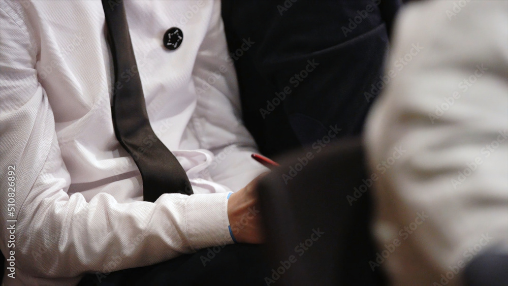 Businessman at the training with a pen in his hands. Stock. Business concept