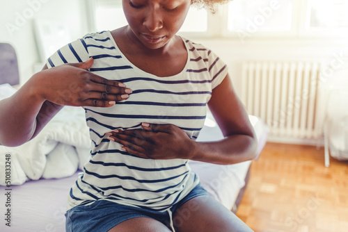 Young woman doing breast self-exam. African woman palpating her breast by herself that she concern about breast cancer. Healthcare and breast cancer concept. Guidelines to check for breast cancer. photo