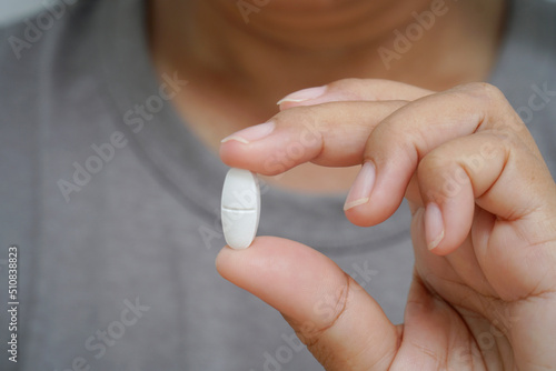 Close Up woman holding Pill showing medicine.