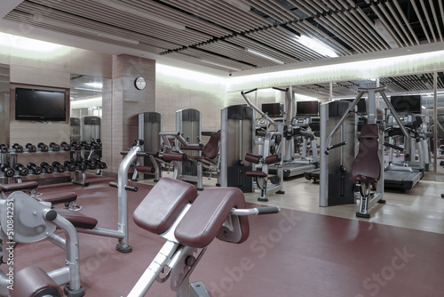 Modern light gym. Sports equipment in gym. Barbells of different weight on rack. 