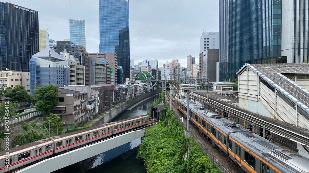 Japanese train tracks and the morning JR train at Ochanomizu station, cloudy weekday year 2022 June 14th, central downtown Tokyo Japan.  