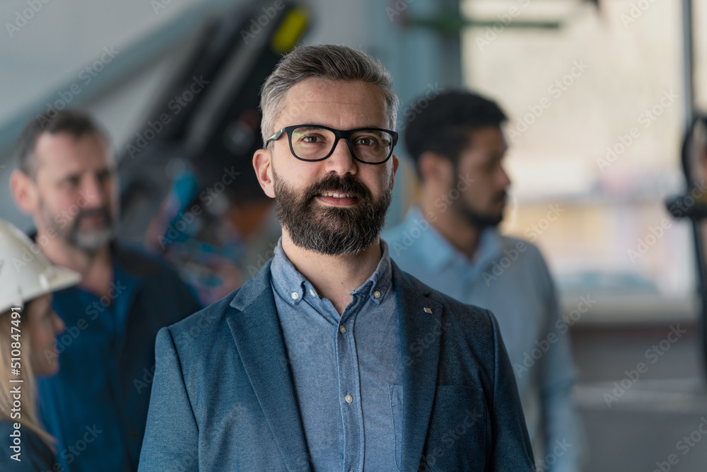 Portrait of male chief engineer in modern industrial factory looking at camera. Portrait of male chief engineer in modern industrial factory looking at camera.