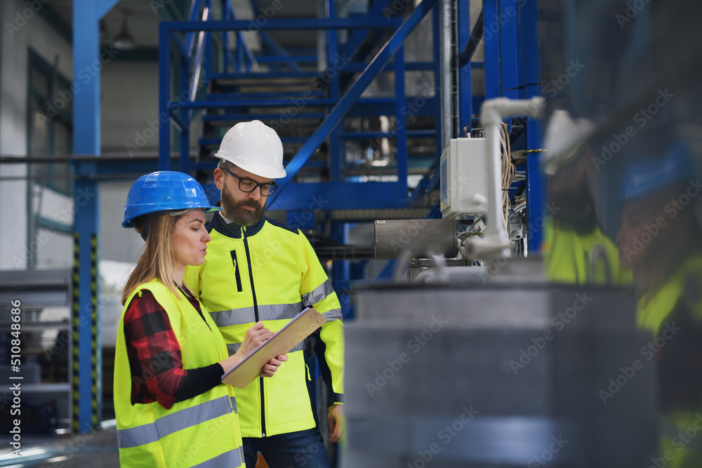 Engineering manager and mechanic worker doing routine check up in industrial factory Engineering manager and mechanic worker doing routine check up in industrial factory