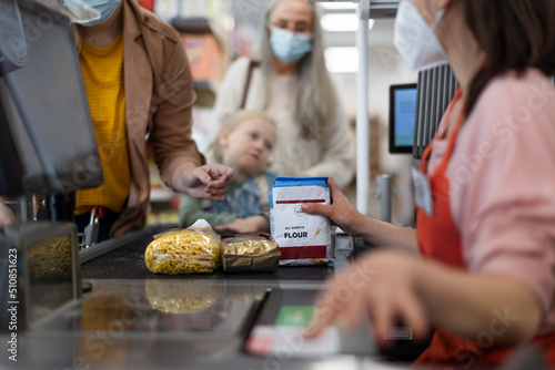 Checkout counter hands of the cashier scans groceries in supermarket, during pandemic. photo