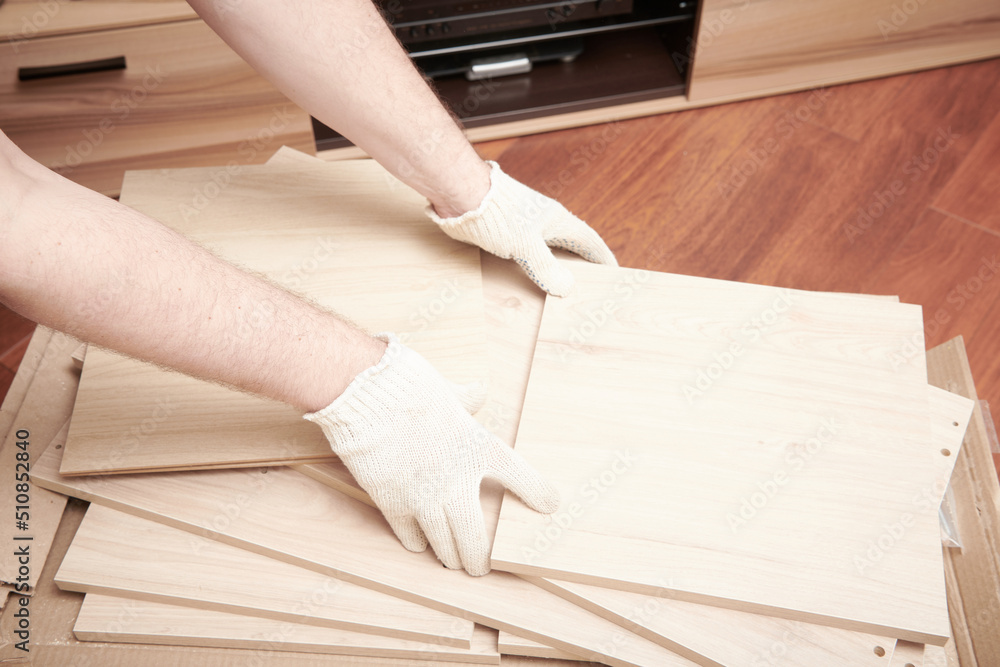 The furniture assembler unpack box with shelf for self assembling. Furniture assembly process at home. DIY Assembling. Close up view The furniture assembler unpack box with shelf for self assembling. Furniture assembly process at home. DIY Assembling. Close up view