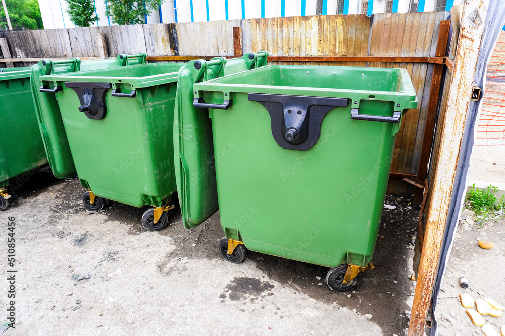 Opened green plastic recycling containers at the street Opened green plastic recycling containers at the street