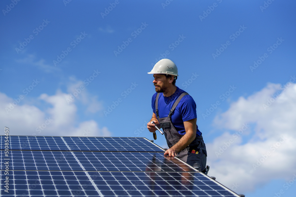 Man worker installing solar photovoltaic panels on roof, alternative energy concept. Man worker installing solar photovoltaic panels on roof, alternative energy concept.