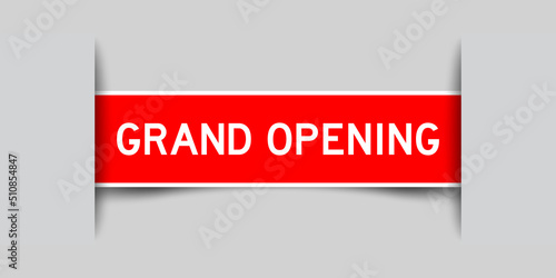 Inserted red color label sticker with word grand opening on gray background