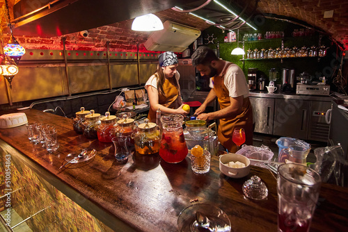 Male and female bartenders are making cocktails