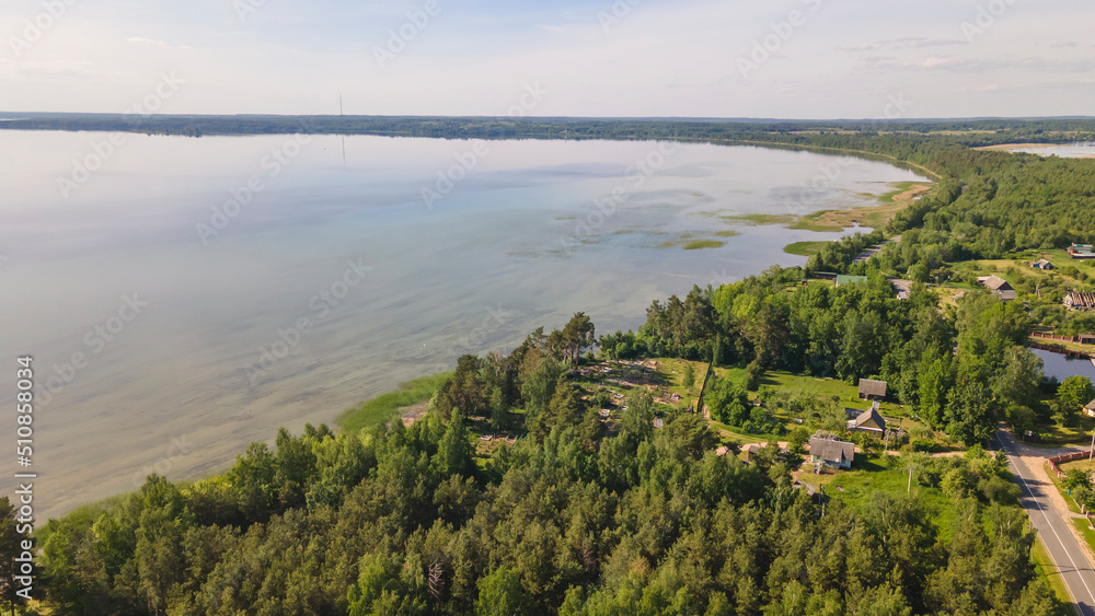 Aerial view of lake with sky reflection. Blue lake and green forest. Image for design. Space for text. Aerial view of lake with sky reflection. Blue lake and green forest. Image for design. Space for text.
