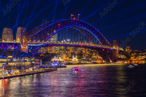 Colourful Light show at night on Sydney Harbour NSW Australia. The bridge illuminated with lasers and neon coloured lights 