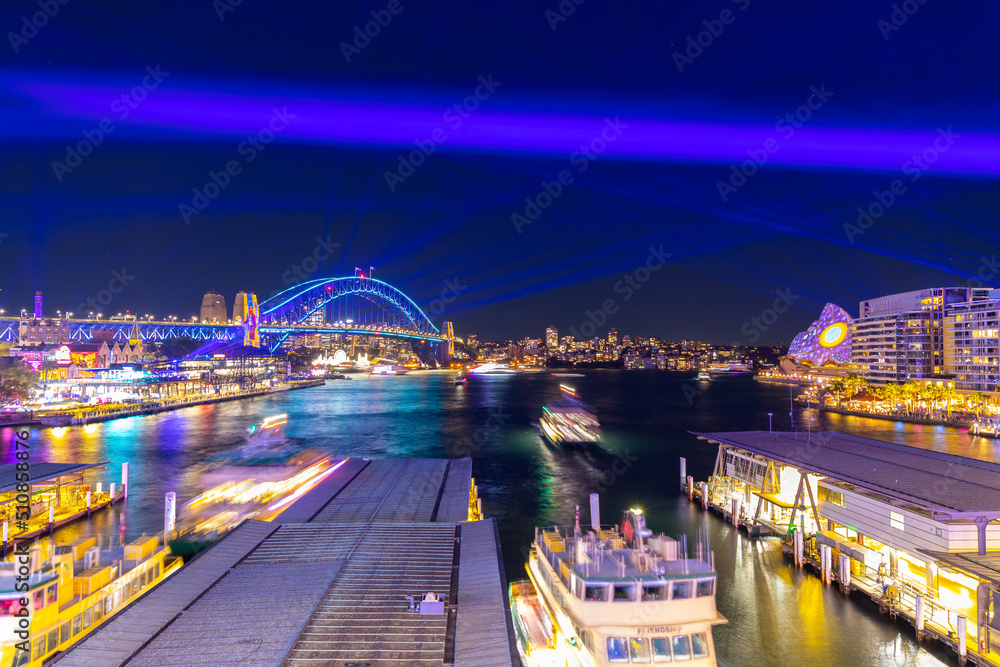 Obraz premium Colourful Light show at night on Sydney Harbour NSW Australia. The bridge illuminated with lasers and neon coloured lights
