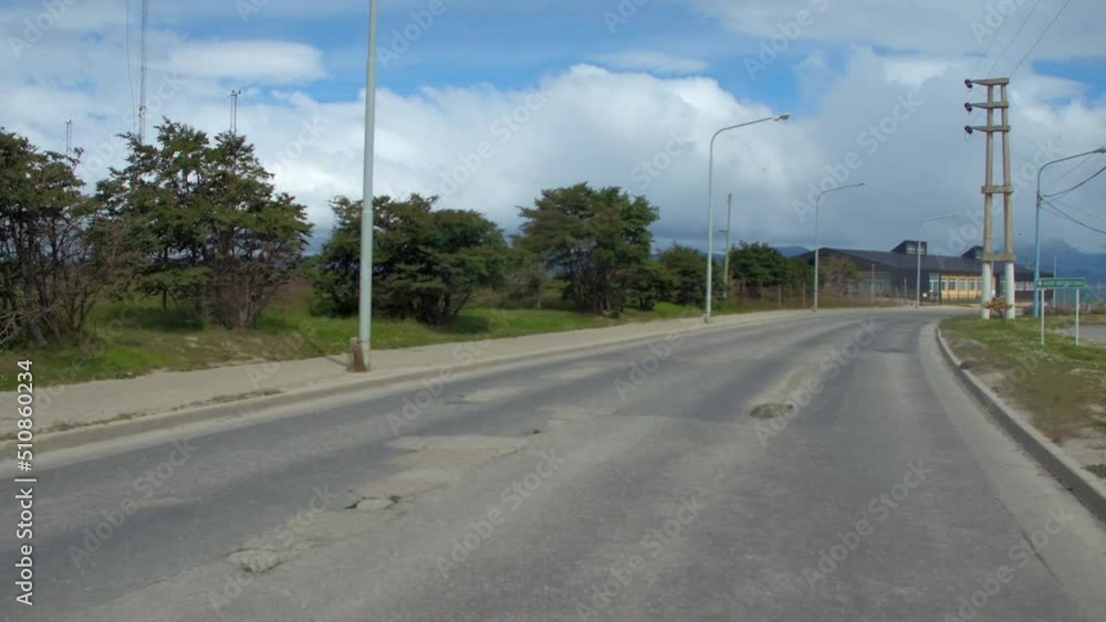 Sea By Mountains Against Cloudy Sky Seen Through Car Moving On Road In Town - Patagonia, Argentina Sea By Mountains Against Cloudy Sky Seen Through Car Moving On Road In Town - Patagonia, Argentina